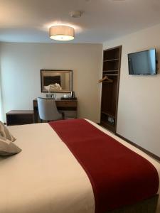 a hotel room with a large bed and a desk at The Draper Rooms in Dublin