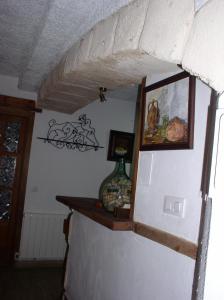 a wall with a mirror and a vase of flowers at La Cueva de Juan Pedro in Cazorla