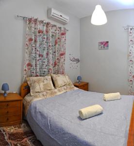 1 dormitorio con 1 cama con manta y ventana en Iro - Kostas House 1, en Chalkida