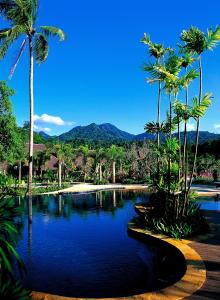 einen Pool mit Palmen und blauem Wasser in der Unterkunft Annika Koh Chang , Formerly Ramayana Koh Chang Resort & Spa in Ko Chang
