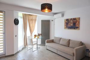 ein Wohnzimmer mit einem Sofa und einem Tisch in der Unterkunft 7 Waves Studio-Spa n Pools beach resort in Mamaia Nord – Năvodari