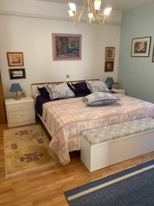 a bedroom with a bed with a bench in it at Rozita Seaside Relax Apartments in Podgora