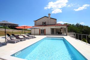 a villa with a swimming pool in front of a house at Villa Minu in Radetići