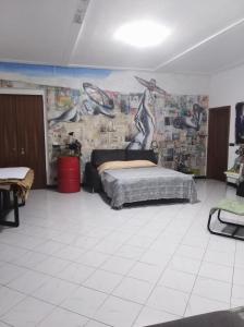 1 dormitorio con 1 cama y un mural en la pared en Stanza d'artista, en Génova