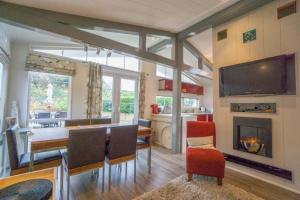 a living room with a dining table and a fireplace at Chalet M6, The Warren, Abersoch in Abersoch