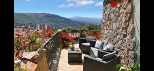 een patio met stoelen en bloemen op een balkon bij Casa Sa Hosta in Gavoi