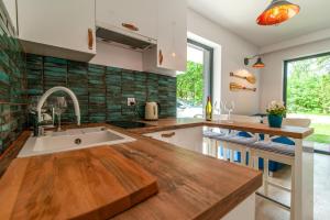 una cucina con piano di lavoro in legno e lavandino di Apartamenty Sailor a Pogorzelica