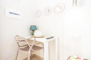 a white desk with a chair and three plates on the wall at HYPNOTIC GUESTHOUSE in Budoni