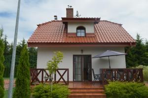 uma pequena casa com um telhado vermelho em Domek nad jeziorem em Dabrówno