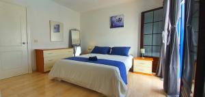 een slaapkamer met een groot bed met blauwe kussens bij Casa Yaiza in Playa Blanca +66 foto's