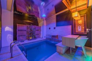a bathroom with a swimming pool with a table and a tub at Dragon Motel (Adult Only) in Fortaleza