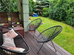 three chairs and a couch sitting on a deck at Wigwam Apartament 8-osobowy in Sopot