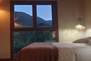 - une chambre avec une grande fenêtre offrant une vue sur la montagne dans l'établissement Ca l'Arcadi, à Alforja