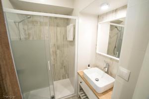 baño blanco con ducha y lavamanos en Apartamento Arcos, en Arcos de la Frontera