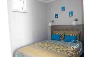 Un dormitorio con una cama con almohadas azules. en MAR I TERRA, en Olhão