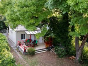 a small white house with a table and chairs at Cottage by the Lake in Balatonudvari