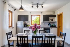 kuchnia ze stołem, na którym stoi wazon z kwiatami w obiekcie Downtown Apartment Helena w mieście Opatija