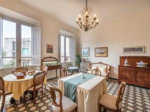 a dining room with a table and chairs and a chandelier at Palazzo Santa Caterina in Dorgali