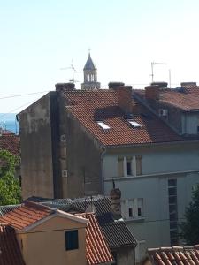 uma vista para os telhados de edifícios com uma torre de relógio em Rooms and Apartment Stambuk em Split