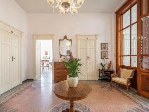 una sala de estar con un jarrón de flores sobre una mesa en Palazzo Santa Caterina, en Dorgali