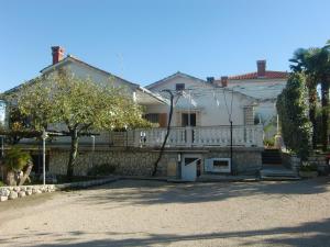 een groot wit huis met een wit hek bij Apartment Marija in Krk