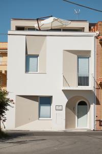 a white building with a balcony on the side at B&B Torreforte in Furnari