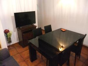 a dining room with a black table and a television at Casa Mateus - Colares, Parque Natural Sintra Cascais in Sintra