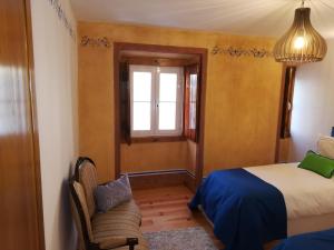a bedroom with a bed and a window and a chair at Casa Mateus - Colares, Parque Natural Sintra Cascais in Sintra