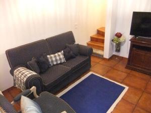 a living room with a couch and a television at Casa Mateus - Colares, Parque Natural Sintra Cascais in Sintra