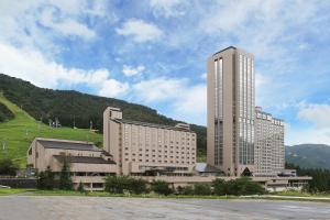 a large building in front of a mountain at NASPA New Otani in Yuzawa