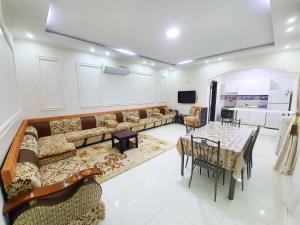 a living room with a couch and a table and chairs at Al Estraha Al Raqia Vila in Al Hada