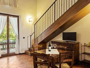 een woonkamer met een tafel, een tv en een trap bij Belvilla by OYO A recently renovated countryhouse in Perugia