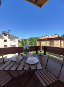 einen Holztisch mit zwei Platten auf dem Balkon in der Unterkunft Apartamento Montes blancos in Jaca