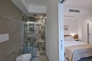 a bathroom with a shower and a bed and a sink at B&B Torreforte in Furnari