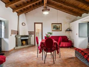 un soggiorno con tavolo e divano rosso di Belvilla by OYO Casa Otaiti a Maniace
