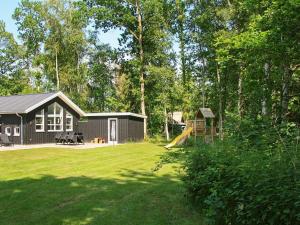 a small cabin with a playground and a slide at 14 person holiday home in Str by in Strøby