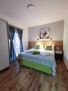 a bedroom with a large bed with a wooden floor at Vila Breza in Soko Banja