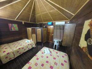 uma vista para um quarto com 2 camas e uma televisão em Chalet Castillo em El Estor