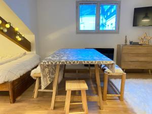 a room with a table and a bed at Joli studio rénové au coeur de Cauterets in Cauterets