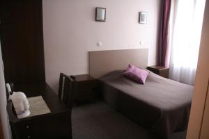 パリにあるオテル デュ ルーションの小さなベッドルーム(紫色の枕付きのベッド付)