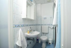 a white bathroom with a sink and a toilet at Apartmani Višković Drašnice in Drašnice