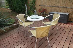 einen Tisch und vier Stühle auf einer Terrasse in der Unterkunft Ferienhaus am Ellerbach in Bad Dürrenberg
