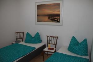 2 Betten mit blauen Kissen in einem Zimmer in der Unterkunft Ferienhaus am Ellerbach in Bad Dürrenberg