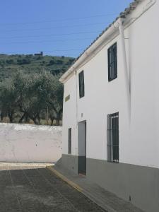 a white building with a door on the side of it at Casa Rural Ventanas a la Sierra in Higuera de la Sierra