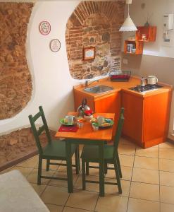 uma cozinha com uma mesa e cadeiras e um lavatório em Oneiro Bed and Relax em Benevento