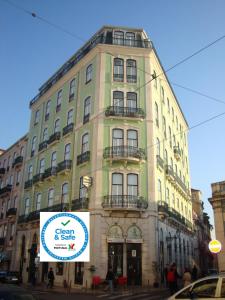 wysoki budynek z znakiem przed nim w obiekcie Pensao Londres w Lizbonie