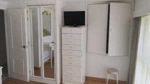 - une chambre avec une commode, une télévision et un miroir dans l'établissement Skol 408A by Completely Marbella, à Marbella