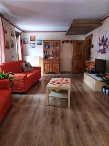 リヴィーニョにあるSky Moda Appartamentoのリビングルーム(赤いソファ、テーブル付)