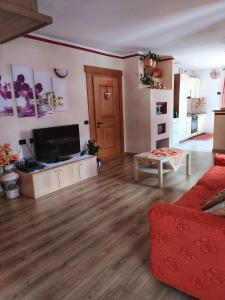 sala de estar con TV de pantalla plana en el suelo de madera en Sky Moda Appartamento, en Livigno