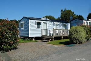 a small house with a porch and a deck at Camping Le Panoramic in Binic